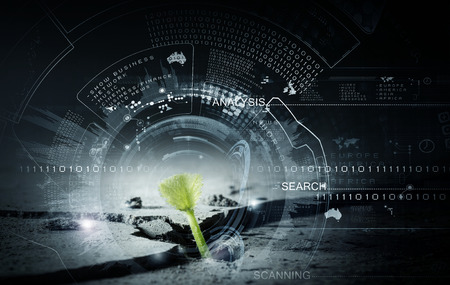 Green growing from crack sprout and digital interfaceの写真素材