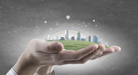 Male hands holding green life concept in palmsの写真素材