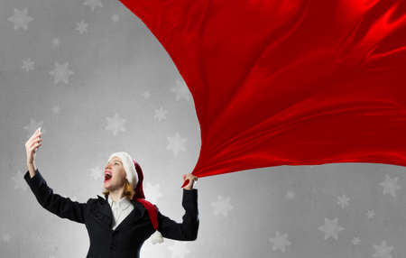 Woman in suit and Santa hat screaming in mobile phoneの写真素材