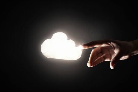 Close up of hand touching with finger glowing cloudの写真素材