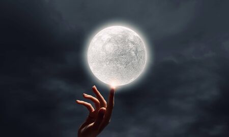 Close up of human hand touching with finger moon planetの写真素材