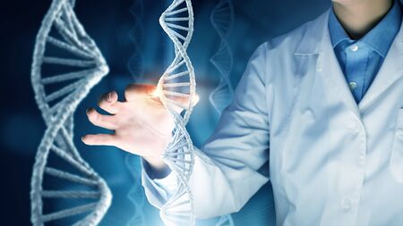 Woman scientist touching DNA molecule image at media screenの写真素材