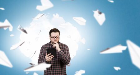 Guy in glasses and checked shirt using tablet pc