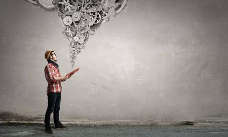 Hipster guy in checked shirt with book in handsの写真素材