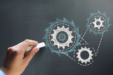 Businessman hand drawing with chalk gears mechanism as teamwork conceptの写真素材