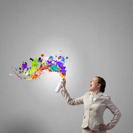 Young elegant businesswoman with white spray balloon in handの写真素材