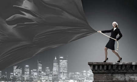 Woman in Santa hat pulling red clothing banner. Place for textの写真素材