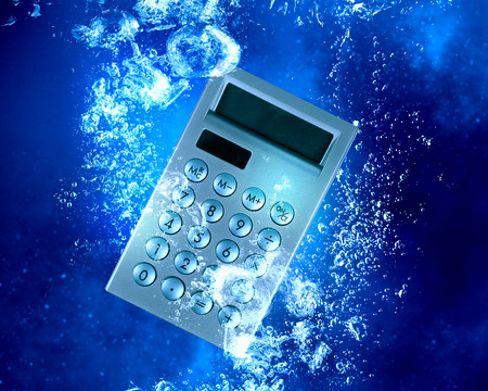 Calculator item sink in clear blue waterの写真素材