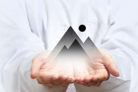 Hand of woman showing house icon in palm on white backgroundの写真素材