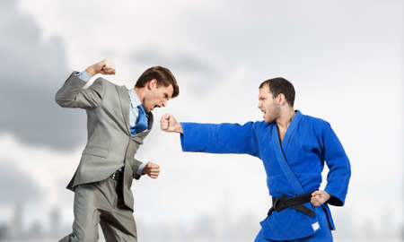 Young determined karate man fighting with businessman in suit