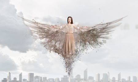 Beautiful woman in long dress with wings in clear skyの写真素材