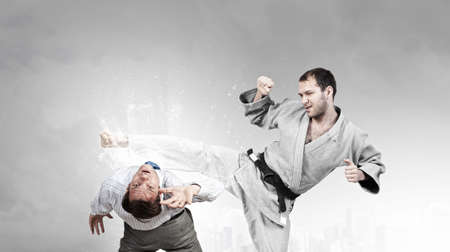Young determined karate man fighting with businessman in suit