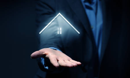 Hand of businessman showing house icon in palmの写真素材