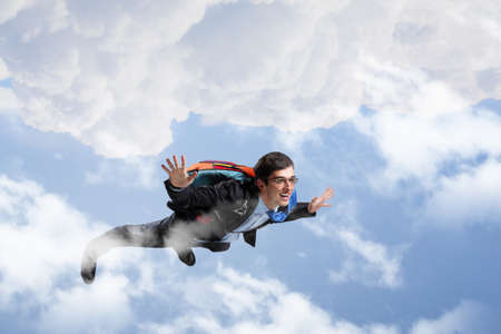 Cheerful businessman with parachute on back flying in sky