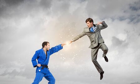 Young determined karate man fighting with businessman in suit