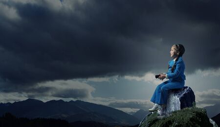 Little girl sitting on top and playing joystickの写真素材