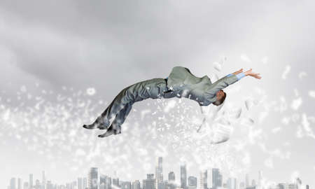 Young determined businessman fighting boxing glove on springの写真素材