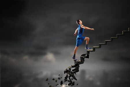 Sports active man running on stone collapsing ladderの写真素材