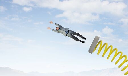 Businessman jumping on springboard as progress concept