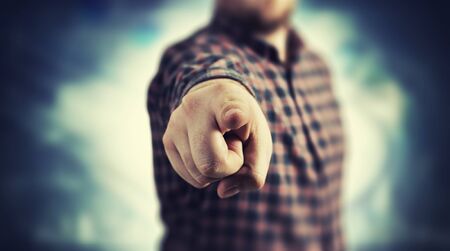 Close up of a man in checked shirt pointing with finger at cameraの写真素材