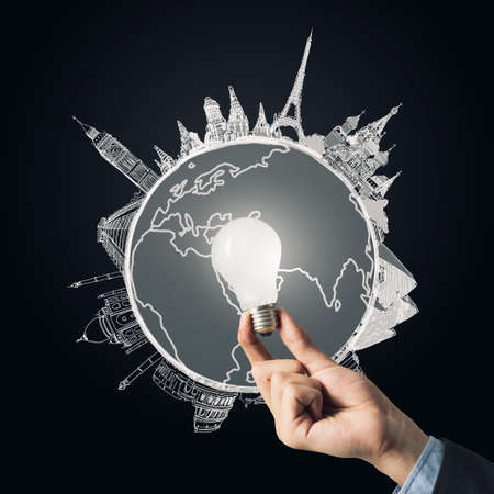 Lit lightbulb held in hand on dark backgroundの写真素材