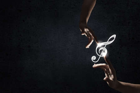 Male hand pointing with finger at music signの写真素材