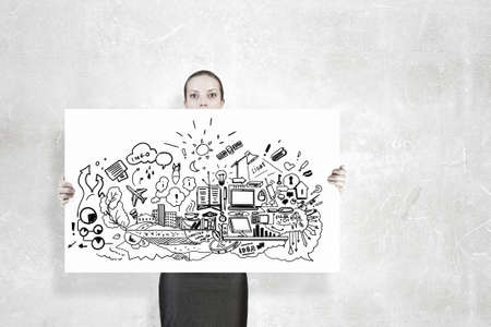 Young businesswoman showing banner with business sketches ideasの写真素材