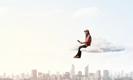 Hipster guy in checked shirt with book in handsの写真素材