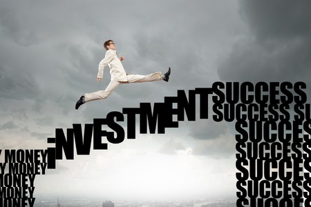 Businessman running on conceptual word bridge over precipiceの写真素材