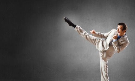Confident businessman ready for fight over gray backgroundの写真素材