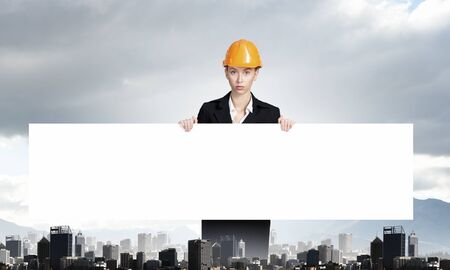 Attractive woman engineer holding white blank banner