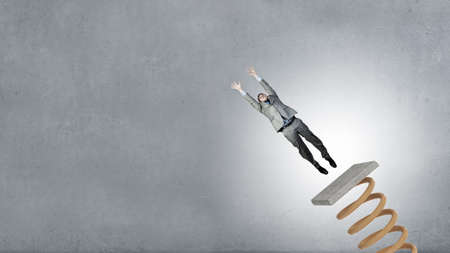 Businessman jumping on springboard as progress concept