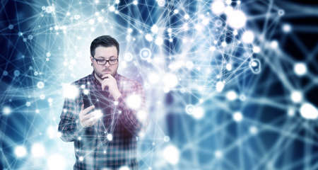 Guy in glasses and checked shirt using tablet pcの写真素材