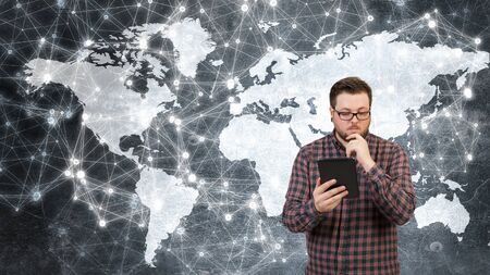 Guy in glasses and checked shirt using tablet pcの写真素材