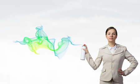 Young elegant businesswoman with white spray balloon in handの写真素材