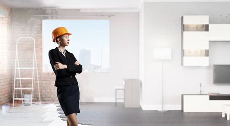Young attractive businesswoman in helmet in modern interiorの写真素材