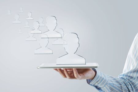 Close up of businessman hand holding tablet and glass symbolsの写真素材