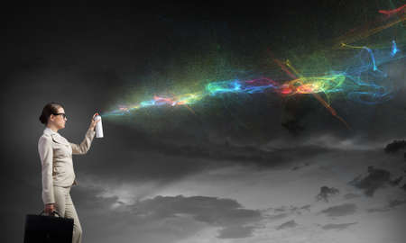 Young elegant businesswoman with white spray balloon in handの写真素材