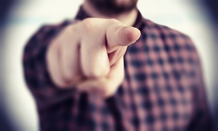 Close up of a man in checked shirt pointing with finger at cameraの写真素材