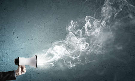 Hand of businessman with megaphone and fume flying out