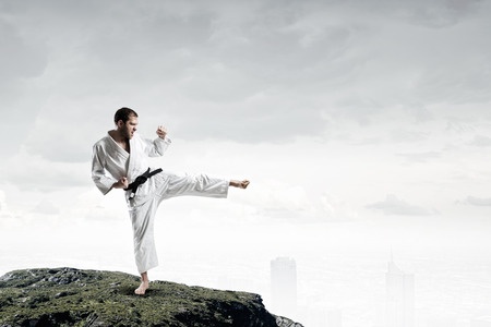 Determined fighter in white kimono show foot kickの写真素材