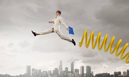 Businessman jumping on springboard as progress conceptの写真素材