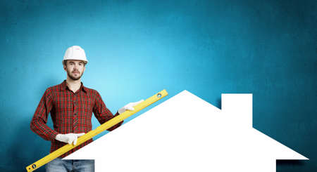 Builder man in checked shirt using measuring levelの写真素材