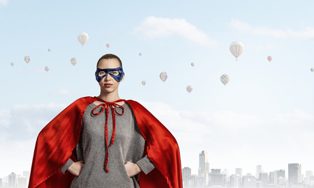 Young confident woman in red cape and maskの写真素材