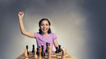 Young caucasian kid girl playing game of chessの写真素材