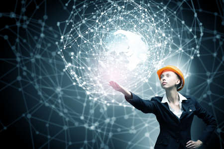 Engineer woman in helmet and global connection conceptの写真素材