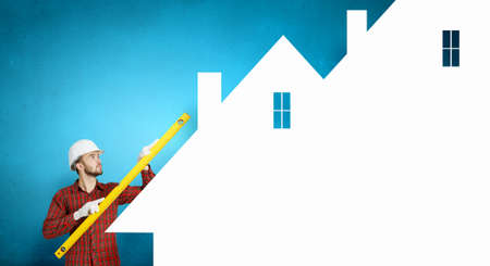 Builder man in checked shirt using measuring levelの写真素材