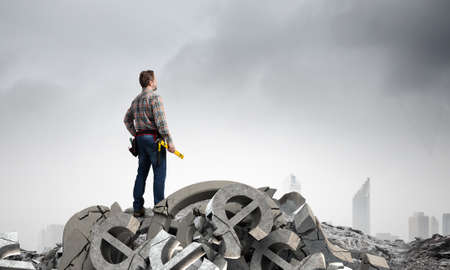 Builder man in checked shirt with tool belt on waist