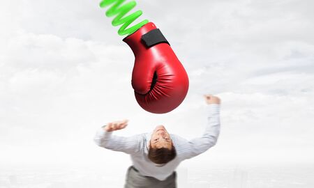 Young determined businessman fighting boxing glove on springの写真素材