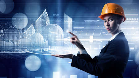 Attractive engineer woman in helmet using virtual panel